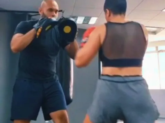 Professor de boxe treinando manopla com aluna na Arena ProFight