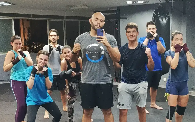 Turma adulta da Arena ProFight em posição de guarda com o professor