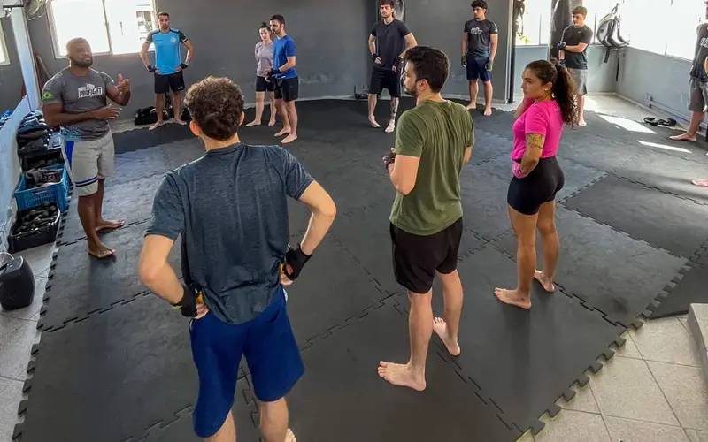 Professor orientando a turma em roda no tatame da Arena ProFight